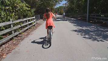 Во время прогулки на велосипеде девушка показывает свою попку